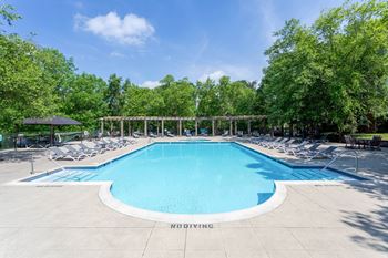A large swimming pool surrounded by trees and lounge chairs.at Riverview Landing @ Valley Forge, Pennsylvania, 19403
